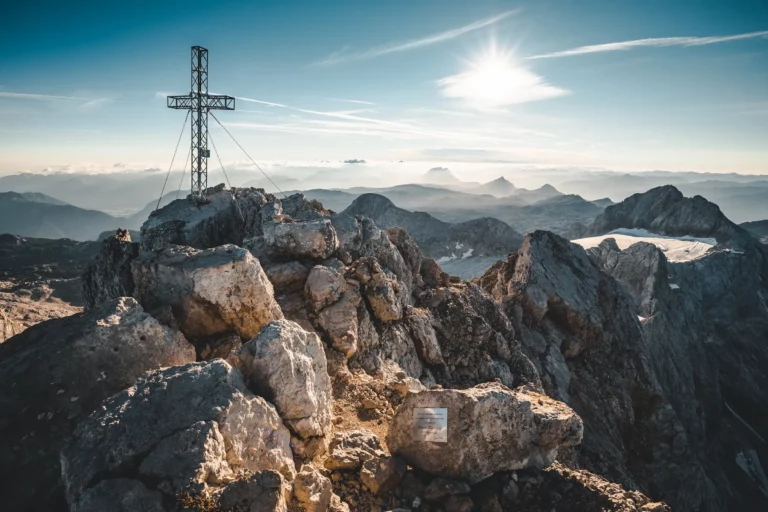 Summit cross above the clouds in the mountains – summer holiday in Ramsau am Dachstein