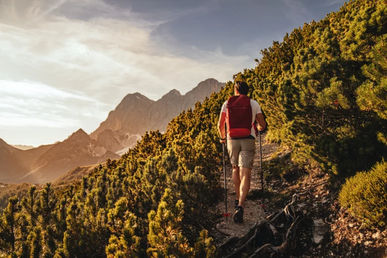 Hiker on a mountain path in an autumn mountain landscape – summer holiday in Ramsau am Dachstein
