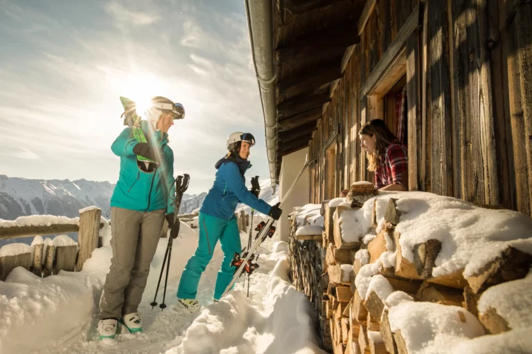 Female skiers at a snowy alpine hut Female skiers at a snowy alpine hut – winter holiday in Ramsau am Dachstein